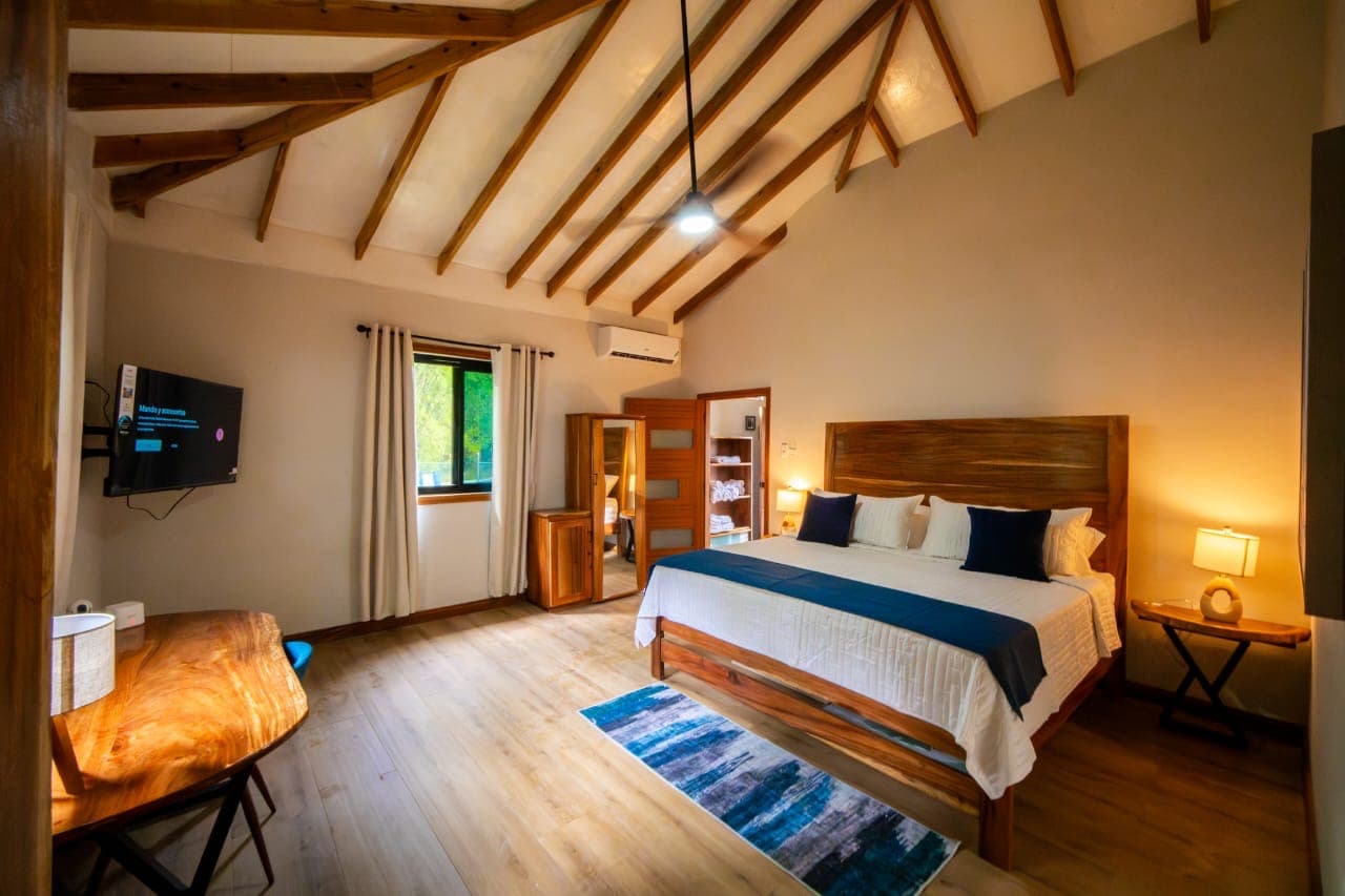 Luxury villa bedroom with wooden beams and natural furnishings